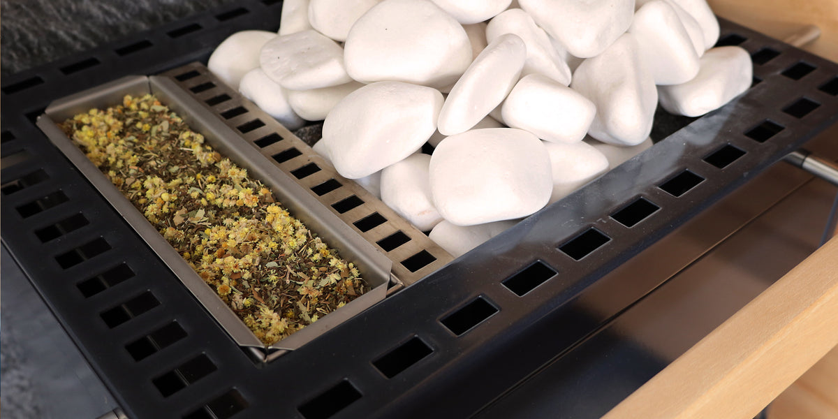 Biosauna-Verdampferofen mit Kamillenblüten auf Kräutersieb, weiße Saunasteine
